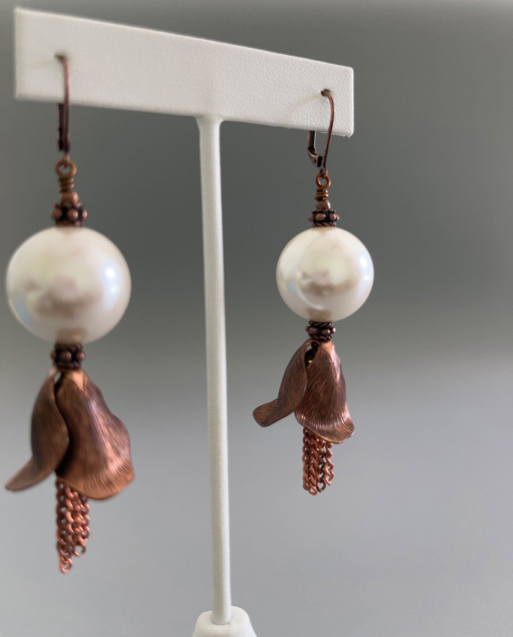 Closer view of copper flower petal and pearl earrings