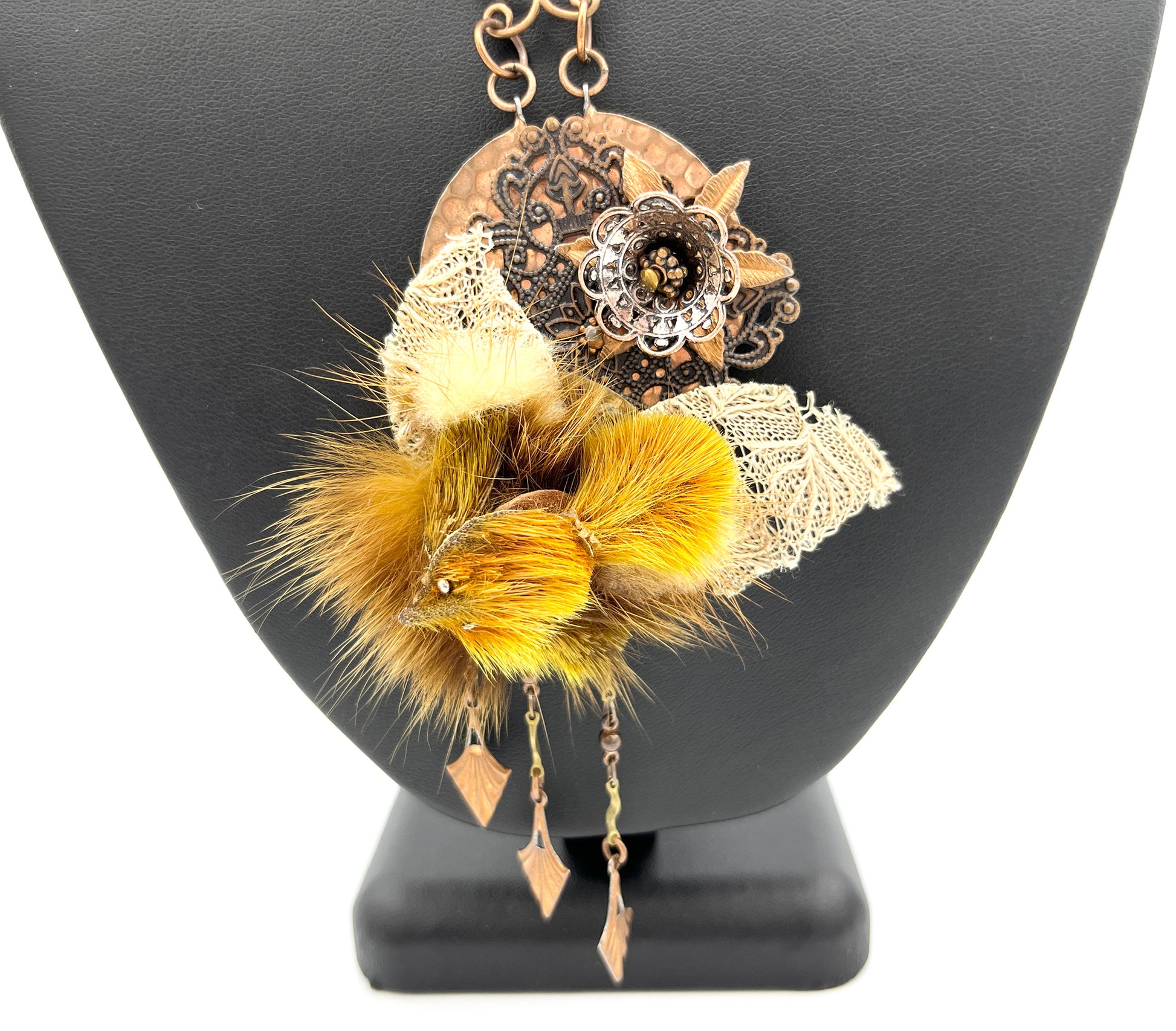 Close view of faux fur and copper pendant